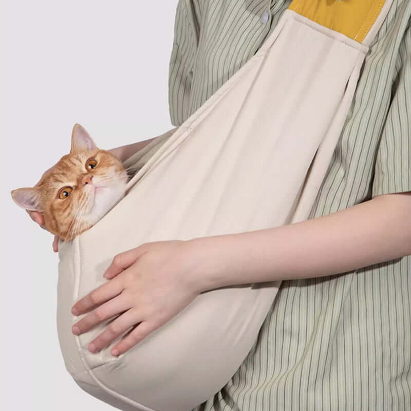Beige crossbody pet sling with soft open-top pouch and wide yellow padded shoulder strap
